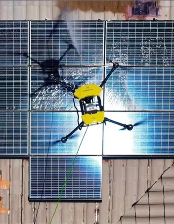 Top-down view of a cleaning drone over rooftop solar panels