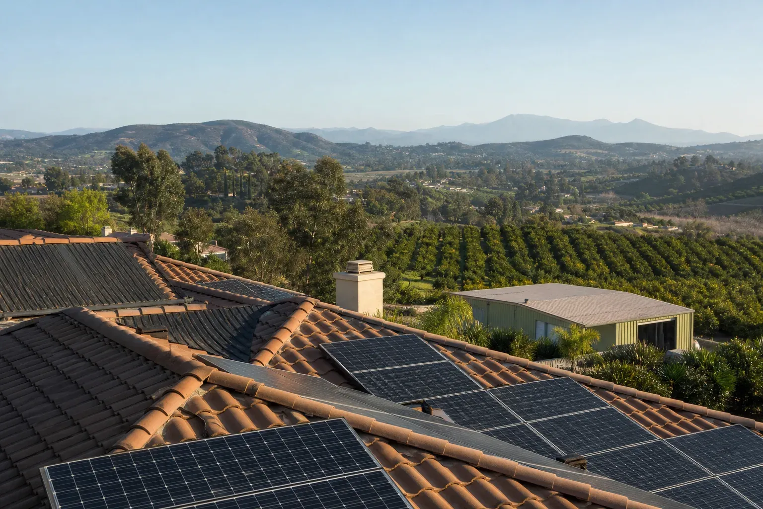 Rooftop solar on a Bonsall estate above avocado groves and rolling North County terrain.