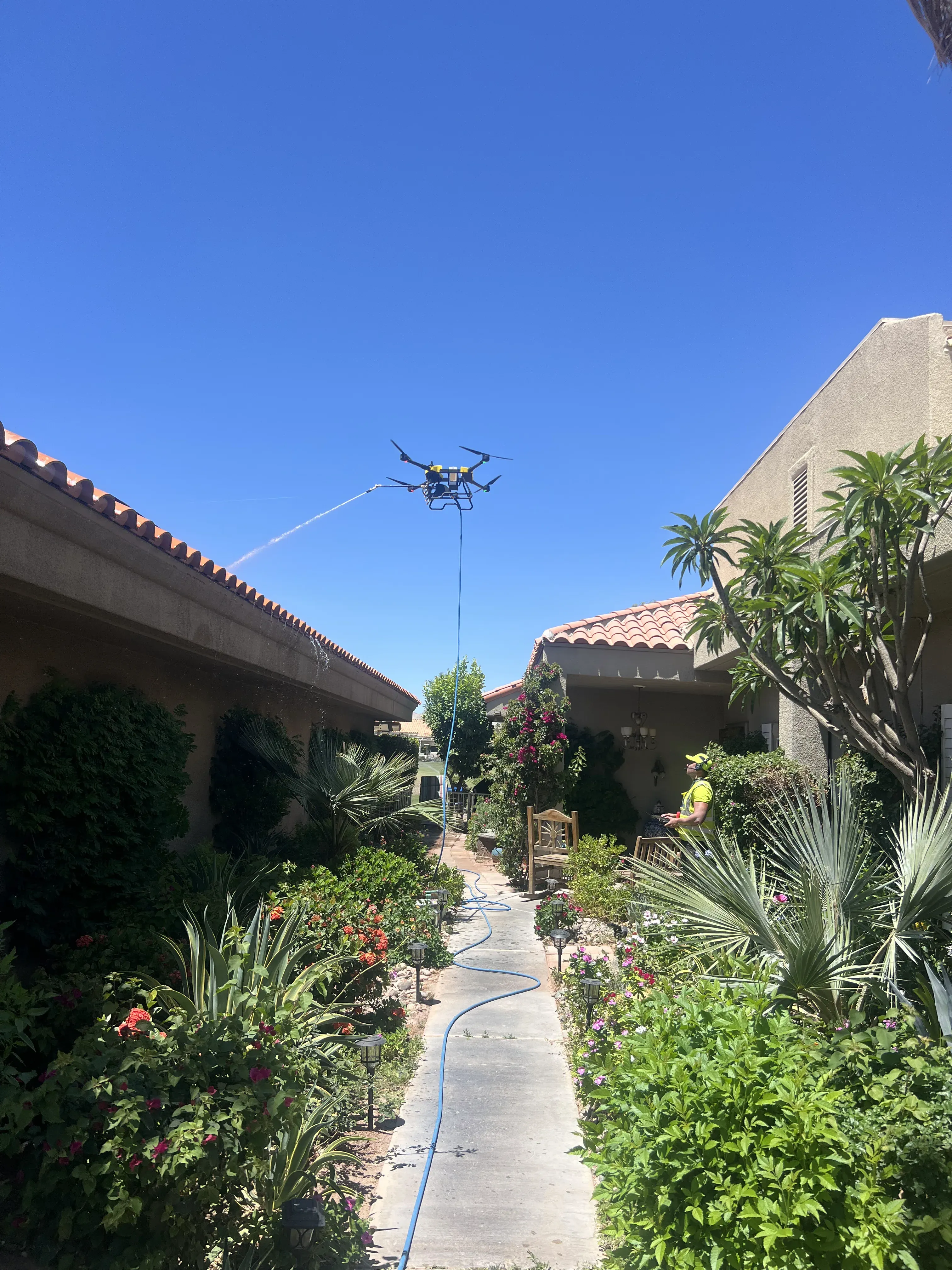 DronePower1 drone hovering between building structures over a courtyard