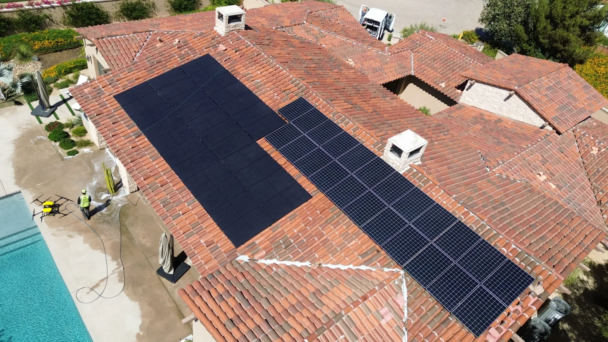 The same tile-roof solar arrays clean and deep black after a DronePower1 drone wash, with the drone and a technician on the wet pool deck and the work van in the driveway