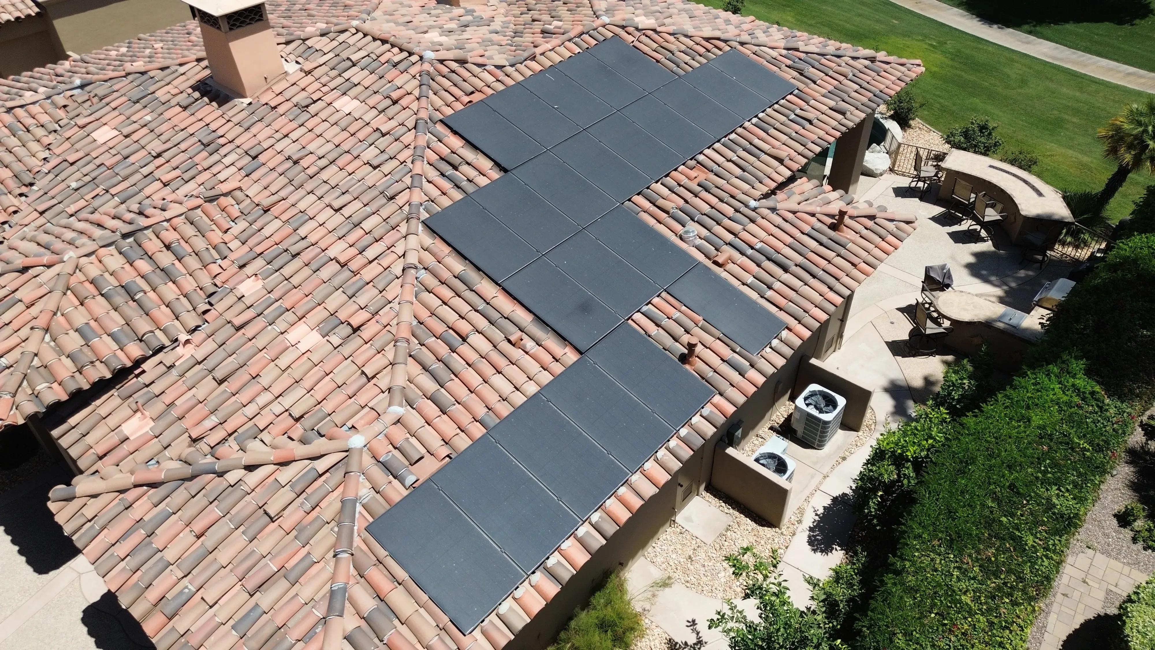 Aerial roof shot showing multiple sections of solar panels across a large surface