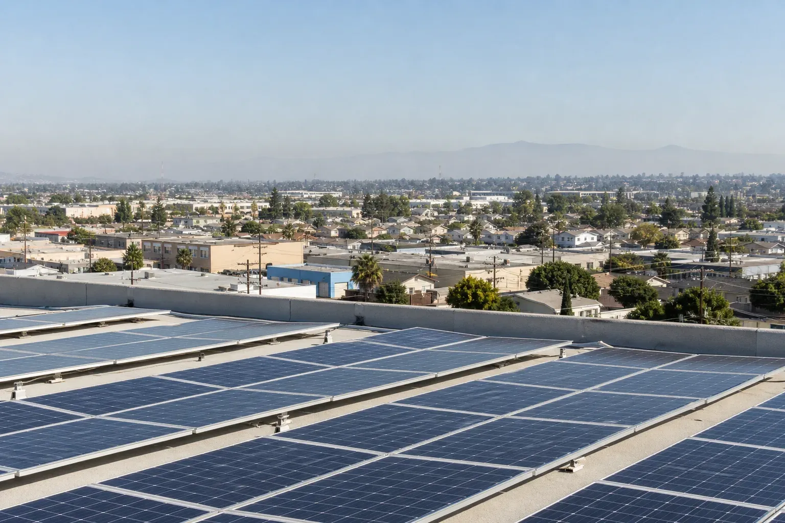 Flat commercial rooftop solar array above the dense Santa Ana urban grid.