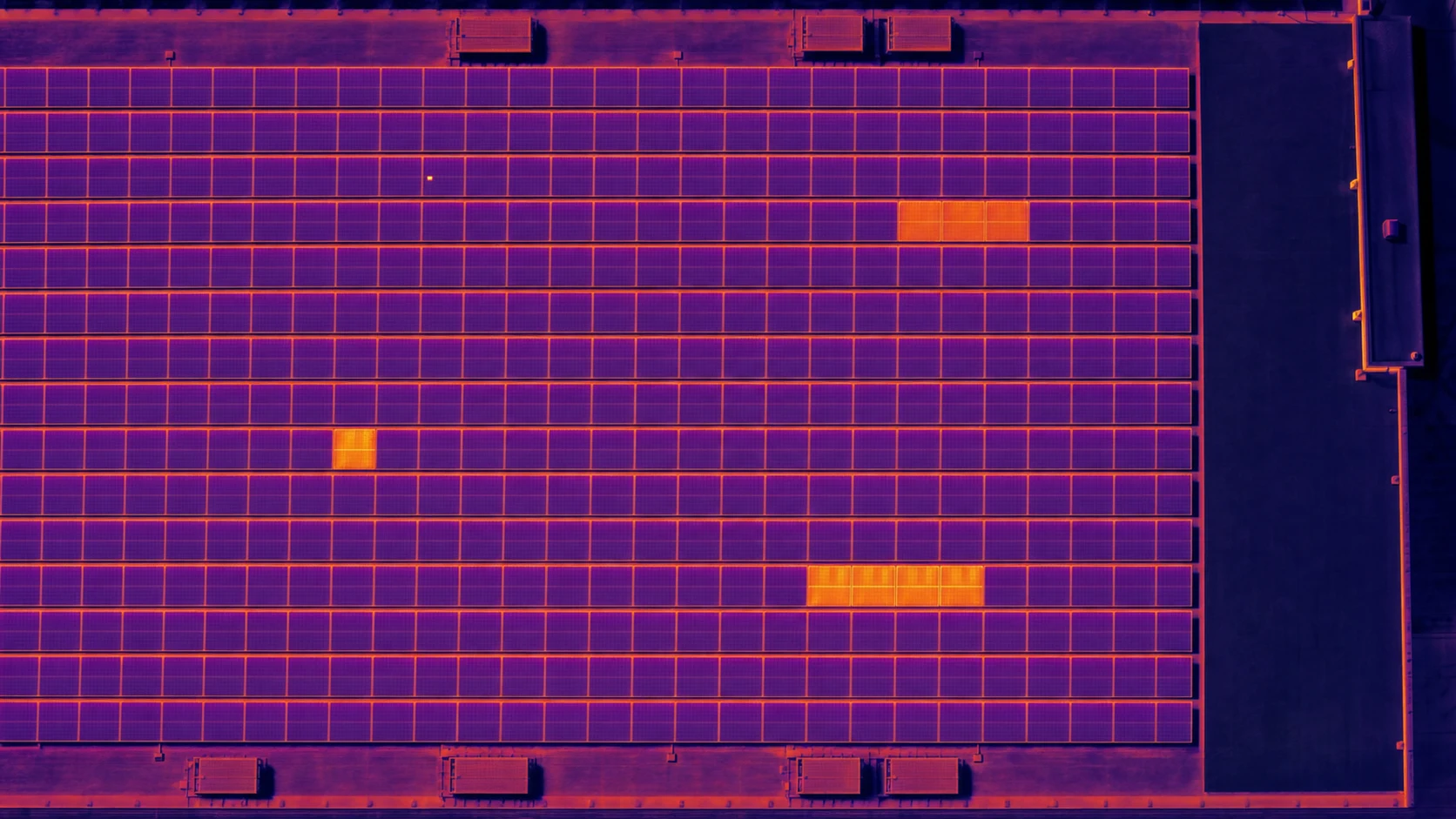 Illustrative top-down thermal view of a commercial solar array with several sparse heat anomalies
