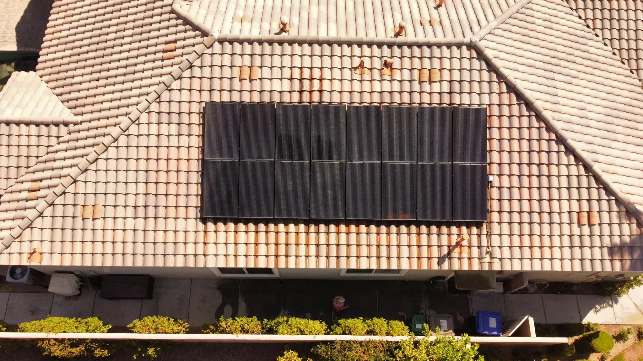 Top-down drone view of the same tile-roof solar array gleaming clean and reflective after a DronePower1 drone cleaning pass